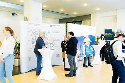 Dornier Hinneburg Managing Director Dr. Goswin Schreck in discussion with interested participants at the company booth during the binding.energy fusion and fission conference