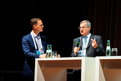 Dr. Angelgiorgio Iorizzo of the European Commission delivers a talk on the Euratom Research and Training Programme while moderator Dr. John Kettler listens attentively on the main stage at binding.energy