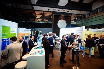 Experts and participants networking with finger food at the binding.energy exhibition, building new industry collaborations among fusion companies like ITER, Bilfinger, Dornier Hinneburg, and digiLab