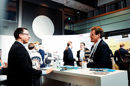Participants of the binding.energy conference engage in dynamic networking and partnership discussions in the exhibition area
