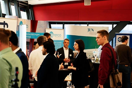 Urenco Germany Managing Director Dr. Jörg Harren visible among exhibitors like Framatome and JEN in the busy binding.energy exhibition hall, following his talk on advanced nuclear fuels and HALEU for next-generation reactors