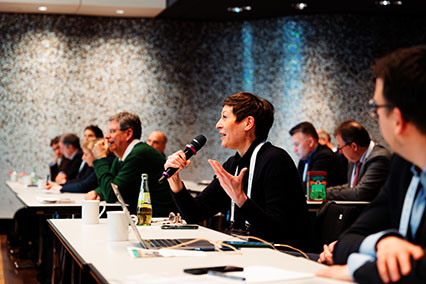 Female nuclear expert in the audience of binding.energy passionately asks a question during the panel on fusion technology innovations, highlighting active engagement and diversity in the field