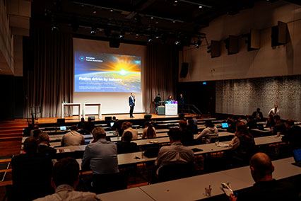 Main stage of binding.energy captured from the audience view during the opening of the session "Fusion driven by industry", featuring the European Fusion Association with moderator Dr. John Kettler introducing the panel