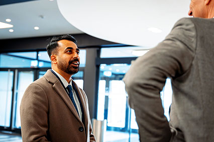 PhD student and nuclear expert engaged in a technical discussion in the lobby of the binding.energy nuclear conference in Aachen