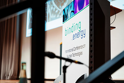 Close-up of speaker podium with binding.energy International Conference on Nuclear Technologies banner at the main stage