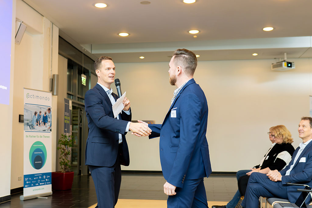 Dr. John Kettler, moderator and organizer of binding.energy, presents a stage award to a young nuclear professional during the Young-Generation Session at the international conference on nuclear technologies.