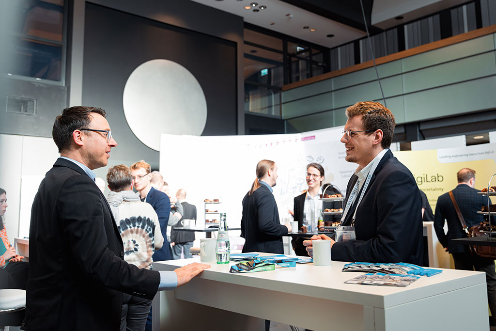 Two nuclear industry professionals engaged in deep conversation at binding.energy conference, highlighting exceptional networking opportunities in fusion and fission sectors.